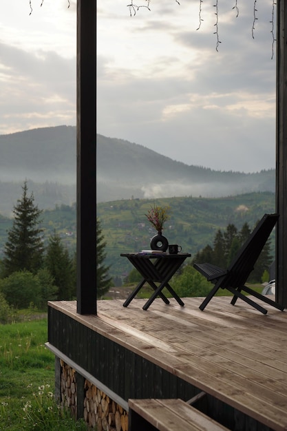 Photo chaise en bois moderne sur terrasse avec vue brumeuse sur les montagnes en ukraine