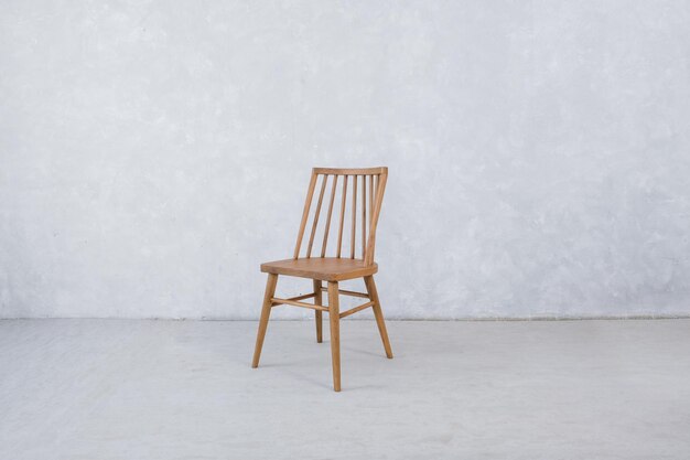 Photo une chaise en bois avec un mur blanc derrière.