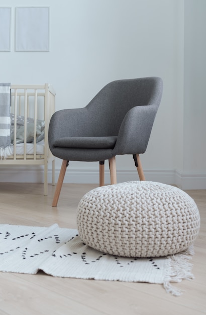 Chaise grise moderne et tabouret soufflé sur un tapis dans la chambre