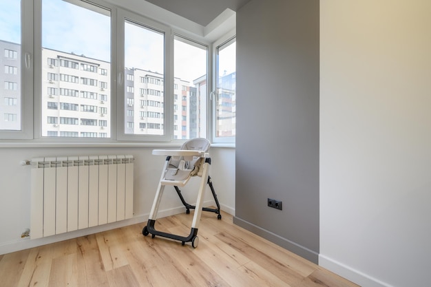 Chaise haute bébé pour manger à la maison à côté de la fenêtre