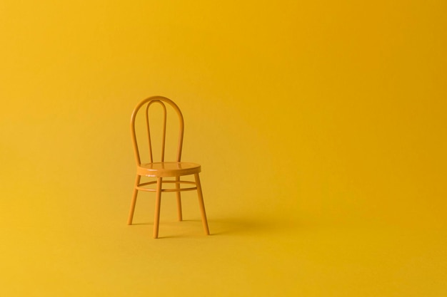 Une chaise jaune vintage sur un fond jaune Espace de copie Concept minimal