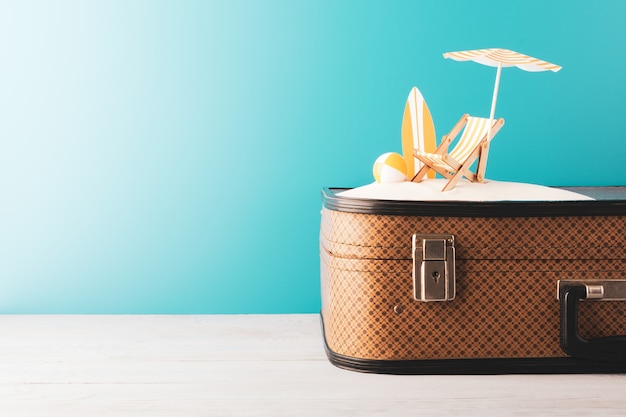 Chaise longue avec planche de surf et ballon gonflable sur étui marron avec faux ciel sur fond