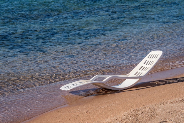 Chaise longue en plastique blanc dans l'eau de mer sur une plage tropicale à Sharm El Sheikh Egypte