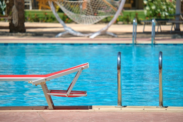 Chaise longue vide au bord de la piscine dans la station balnéaire. Concept de vacances et d'escapade.