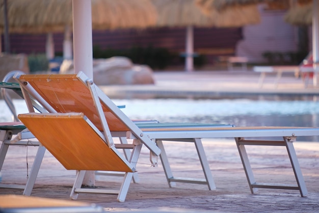 Chaise longue vide au bord de la piscine dans la station estivale Vacances et concept d'escapade