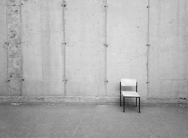 Chaise minimaliste au milieu du fond de rue grunge