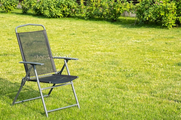 Chaise noire vide dans le jardin. Espace texte