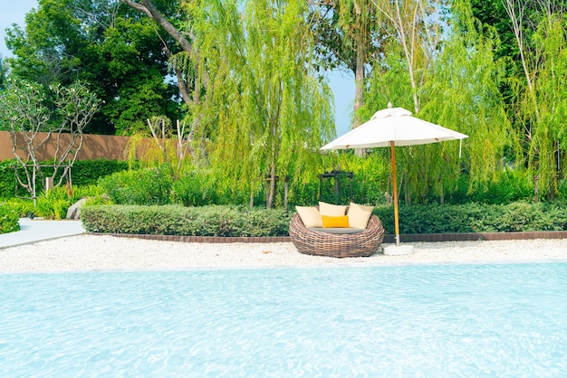 chaise de patio extérieur avec oreiller et parasol autour de la piscine - vacances et concept de vacances