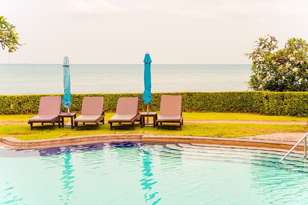 chaise de piscine avec parasol autour de la piscine