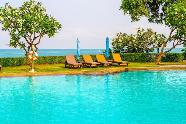 Chaise piscine ou piscine lit et parasol autour de la piscine avec fond de mer