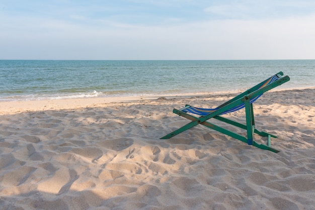 chaise de plage en bois vide au fond de la plage