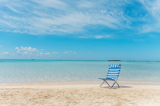 Chaise sur la plage tropicale au bord de l'eau