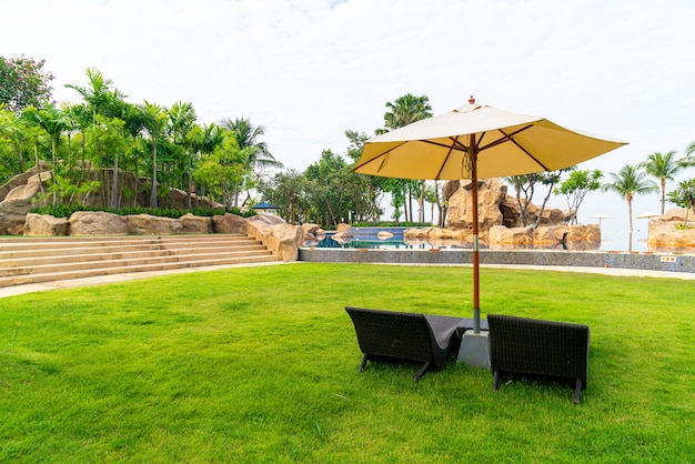 Chaise de plage vide avec parasol autour de la piscine