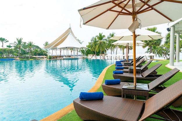 Chaise de plage vide avec parasol autour de la piscine