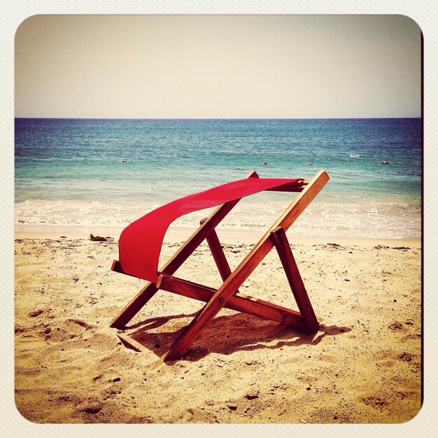 Photo une chaise de pont sur la plage