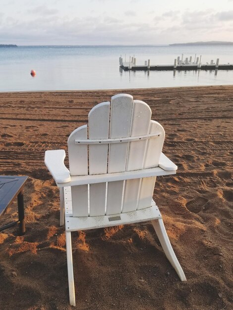 Photo une chaise de pont sur le sable sur la plage contre le ciel