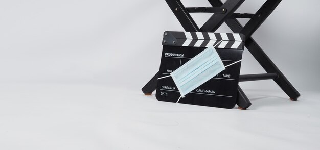 Chaise de réalisateur et tableau noir Clapper ou ardoise de film avec masque facial. il est utilisé dans la production vidéo et l'industrie du cinéma sur fond blanc.