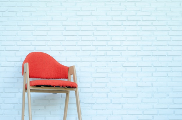 Chaise rouge sur fond de briques blanches, salle moderne, espace copie.