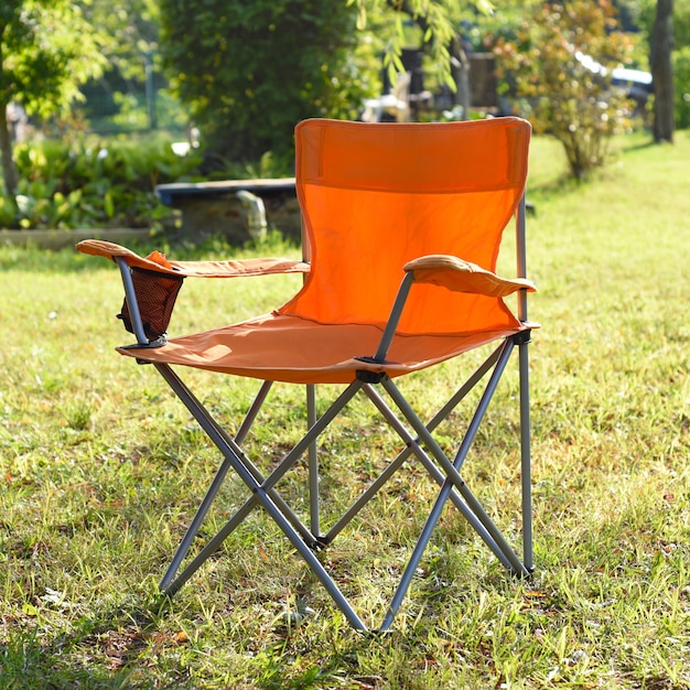 Chaise touristique pliante debout à l'extérieur sur l'herbe