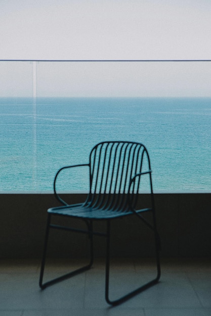 Une chaise vide contre la mer contre un ciel clair