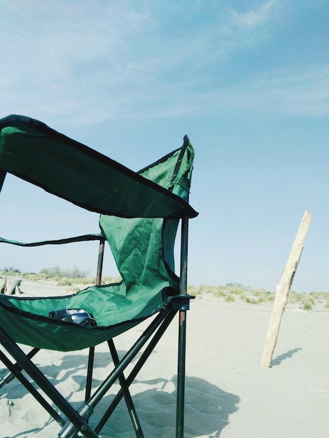 Photo une chaise vide sur la plage contre le ciel