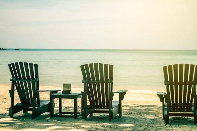 Des chaises Adirondack vides sur la plage contre le ciel
