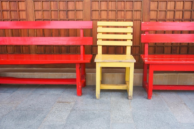 Chaises de banc en bois rouges et jaunes dans le parc.