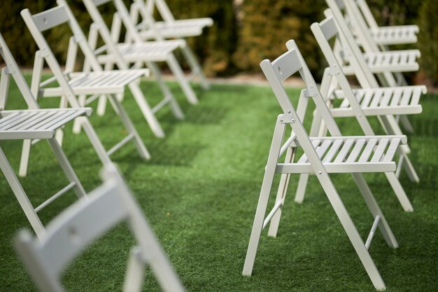 Chaises en bois blanc lors d'une cérémonie festive Cérémonie de mariage en plein air