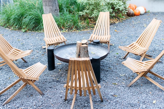 Chaises en bois disposées en cercle. Lieu de repos avec cheminée et chaises autour.