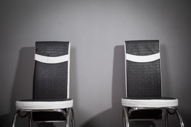 Chaises de bureau en cuir noir et blanc sur fond gris