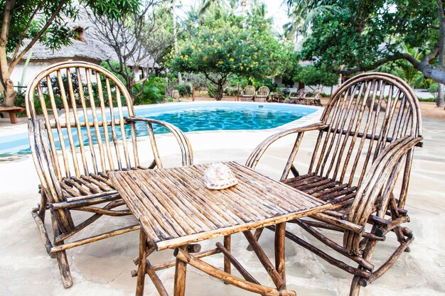 Chaises élégantes en bois près d'une piscine à l'intérieur d'un jardin kenyan