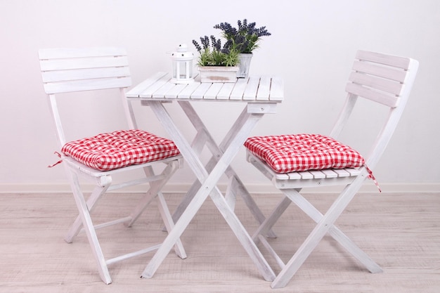 Chaises de jardin et table avec des fleurs sur fond blanc