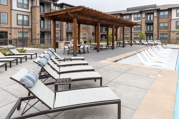 Chaises longues dans la cour arrière de la zone de loisirs du complexe résidentiel et de la salle à manger sur le toit