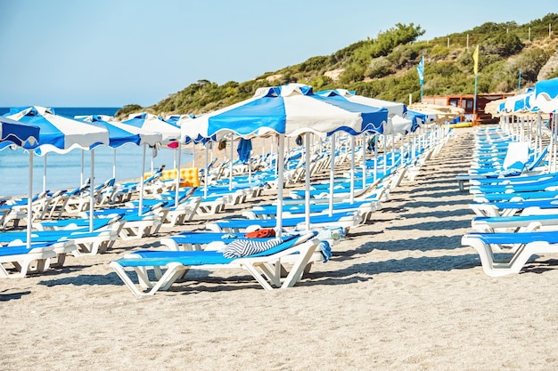 Chaises longues et parasols de couleur bleu et blanc sur la plage