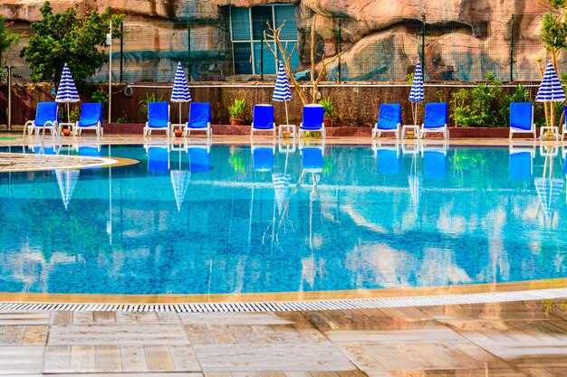 Chaises longues et parasols vides près de la piscine