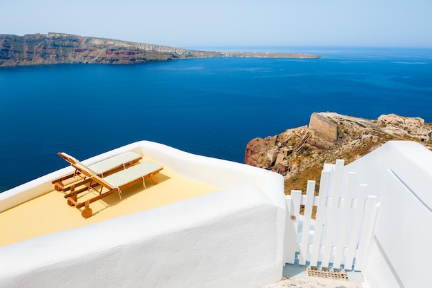 Chaises longues sur la terrasse avec vue mer. L'île de Santorin, Grèce