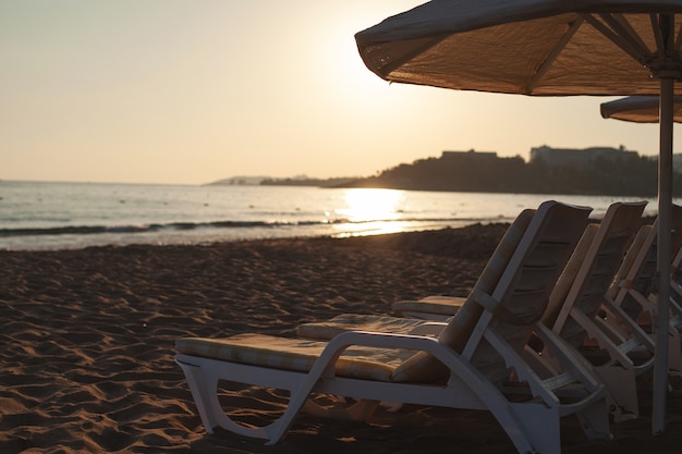 Chaises longues et transats gratuits sur la plage. photo douce et lumineuse