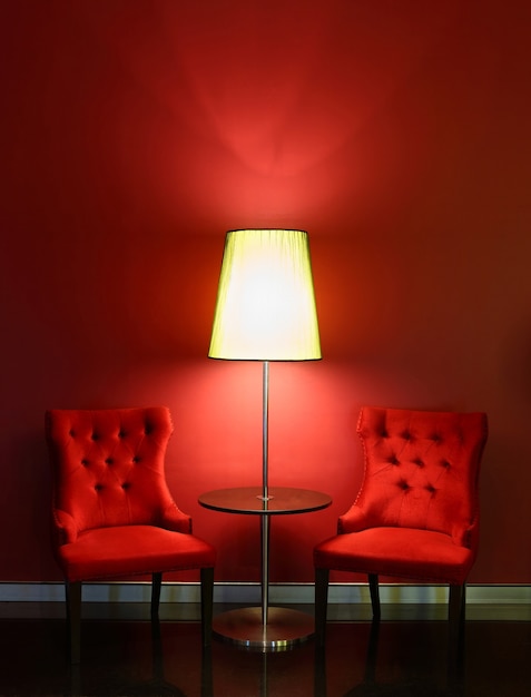 Chaises de luxe rouges avec table et lampe