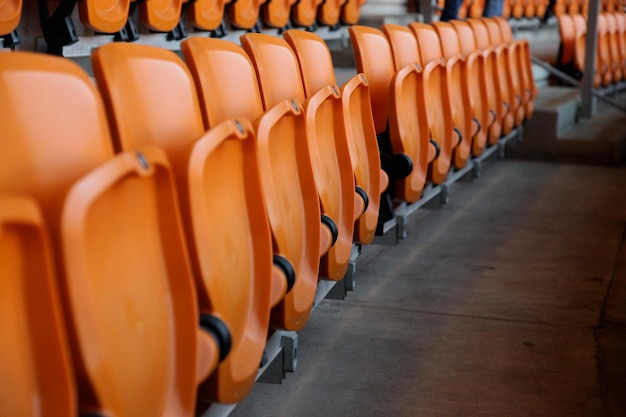 Des chaises orange vides dans le stade.