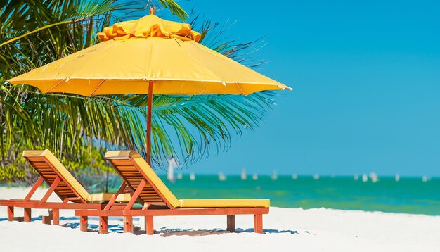 Photo des chaises et un parapluie dans une bannière de vacances tropicales à palm beach