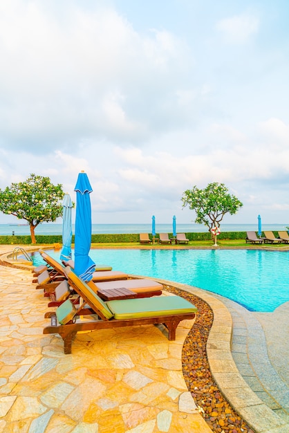 Chaises de piscine et parasol autour de la piscine