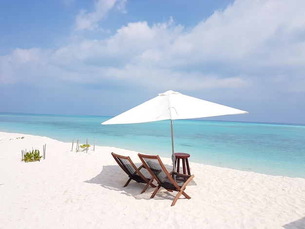 Des chaises sur la plage contre le ciel