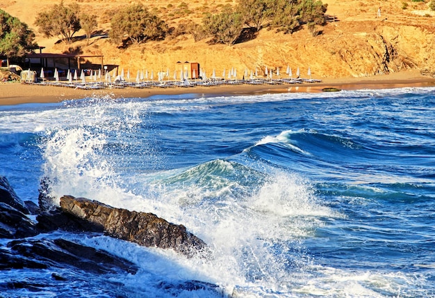 Chaises de plage et mer agitée au resort dans le village de panormos sur l'île de Crète en Grèce