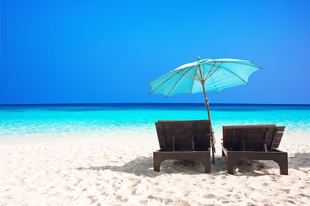 Chaises de plage avec parasol et belle plage de sable