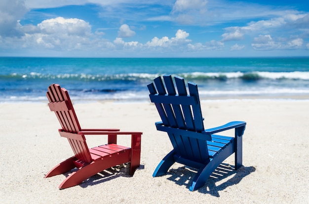 Chaises de plage rouge et bleu près de l'océan