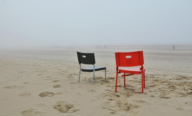 Photo des chaises sur une plage de sable contre le ciel