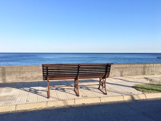 Des chaises de pont sur la plage contre un ciel bleu clair