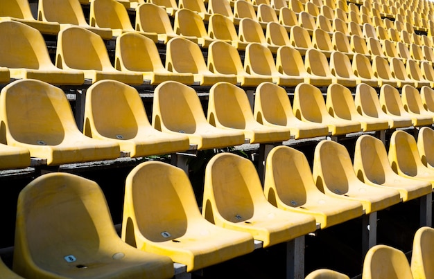 Chaises pour le public concept d'environnement culturel couleur et symétrie sièges vides stade moderne tribunes jaunes sièges de tribune sur le stade de sport arène extérieure vide concept de fans