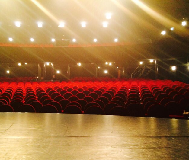 Photo des chaises rouges vides dans un théâtre éclairé