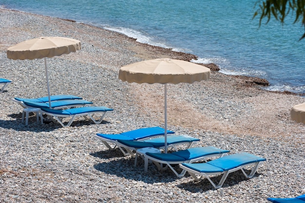 Des chaises solaires et des parapluies sur la plage